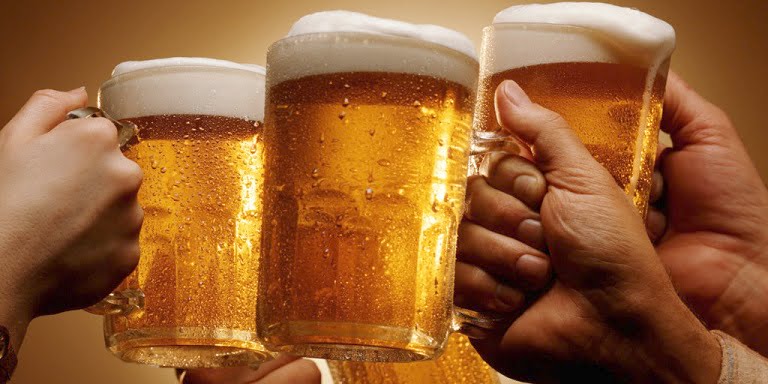FOUR HANDS MALE AND FEMALE TOAST WITH MUGS OF BEER