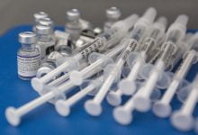 Syringes and vials of Pfizer-BioNTech COVID-19 vaccine are seen on a work surface during a drive-through clinic at St. Lawrence College in Kingston, Ont., on Dec. 18, 2021. (The Canadian Press/Lars Hagberg)