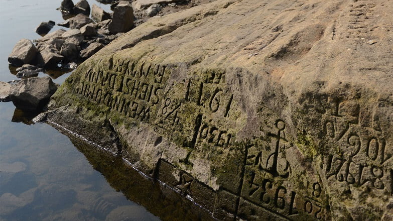 Several of the ‘hunger stones’ are revealed by the low level of water in Worms, Germany. Credit: Reuters