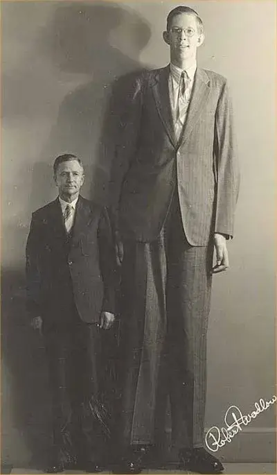 The tallest man who ever lived, Robert Wadlow, with his father, who appears grumpy probably because of all the money he had to spend on his son's giant clothes? (Wikimedia)