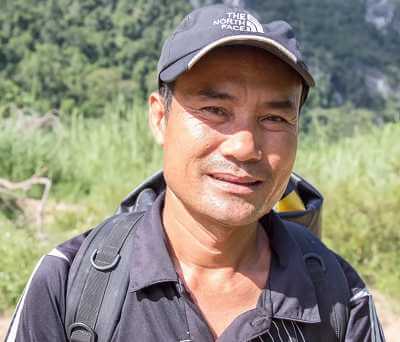 Ho Khanh is a Vietnamese logger born in the rural hills of Phong Nha, an area then ravaged by starvation and malaria. After losing his father in the Vietnam War (or the “American War” as it is known in Vietnam), Ho Khanh began foraging for precious wood to earn money for his family. In turn, he became a master of the jungle. Image Credit: YouTube screencap