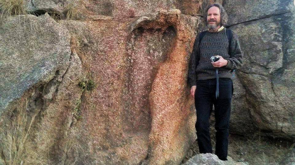 Overview image of Robert Schoch standing near the strange granite impression that has been controversially interpreted as a giant footprint. 