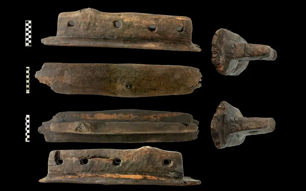 Aerial and side images show the T-shaped object found at the site, with holes likely drilled for rope, allowing towing. 