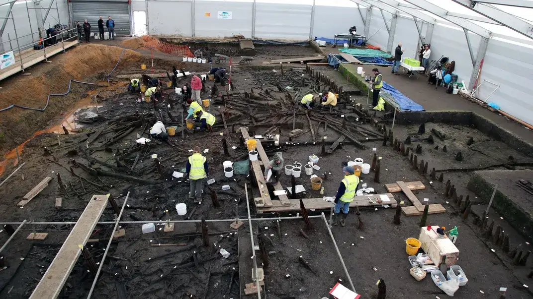 Researchers study the remains of the burned down village from the Bronze Age. As the materials sank into the river, oxygen-poor silt preserved them to the present day. Cambridge Archaeological Unit