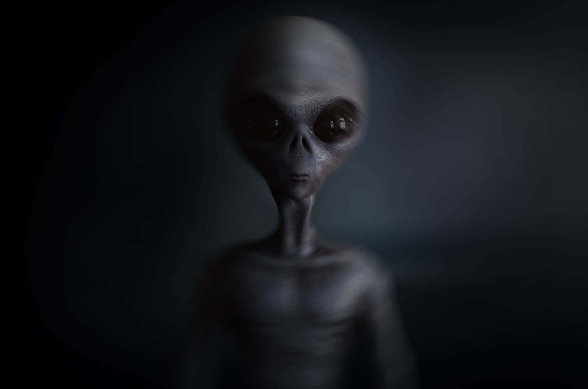 An eerie alien-like figure with large black eyes and smooth skin, possibly captured in a leaked NASA extraterrestrial image.