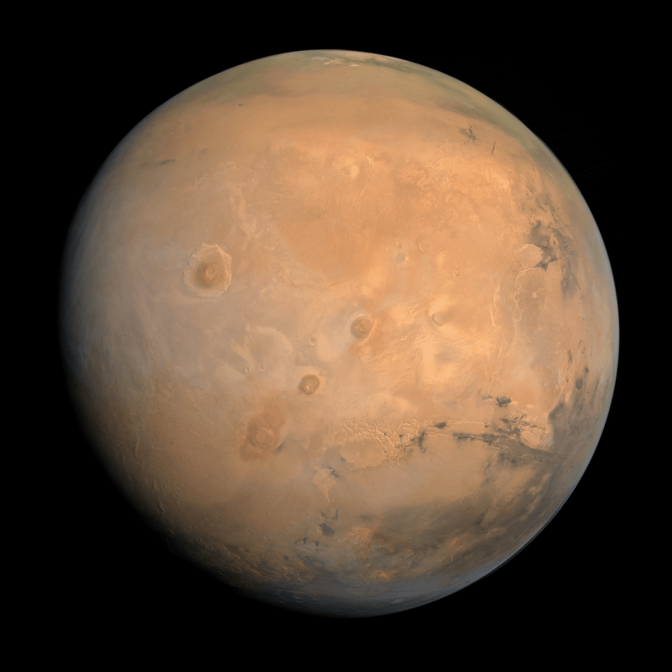 Mars in true colour, as captured by the Hope orbiter. The Tharsis Montes can be seen at the centre, with Olympus Mons just to the left and Valles Marineris at the right. 