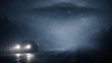 UFO hovering over a misty road with a car.